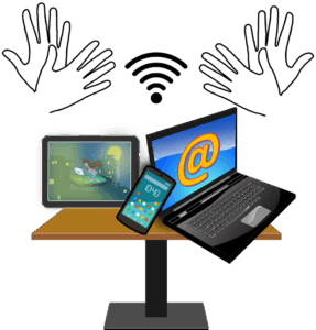 verschiedene technische Geräte (Tablet, Smartphone,..) auf einem Tisch darüber gebärdende Hände