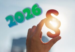 Hand hält ein Paragrafen-Symbol ins Sonnenlicht, daneben die Jahreszahl 2026