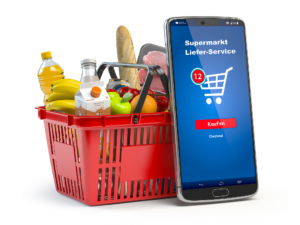 fotorealistische Darstellung eines roten  gut gefüllten Einkaufskorbes davor ein überdimensionales Smartphone auf dem man eine no-name App für Online-Supermarkt-Kauf sieht, ebenfalls mit Einkaufswagen
