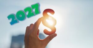 Hand, die ein Paragrafen-Symbol ins Sonnenlicht hält. Daneben am Himmel die Jahreszahl 2027